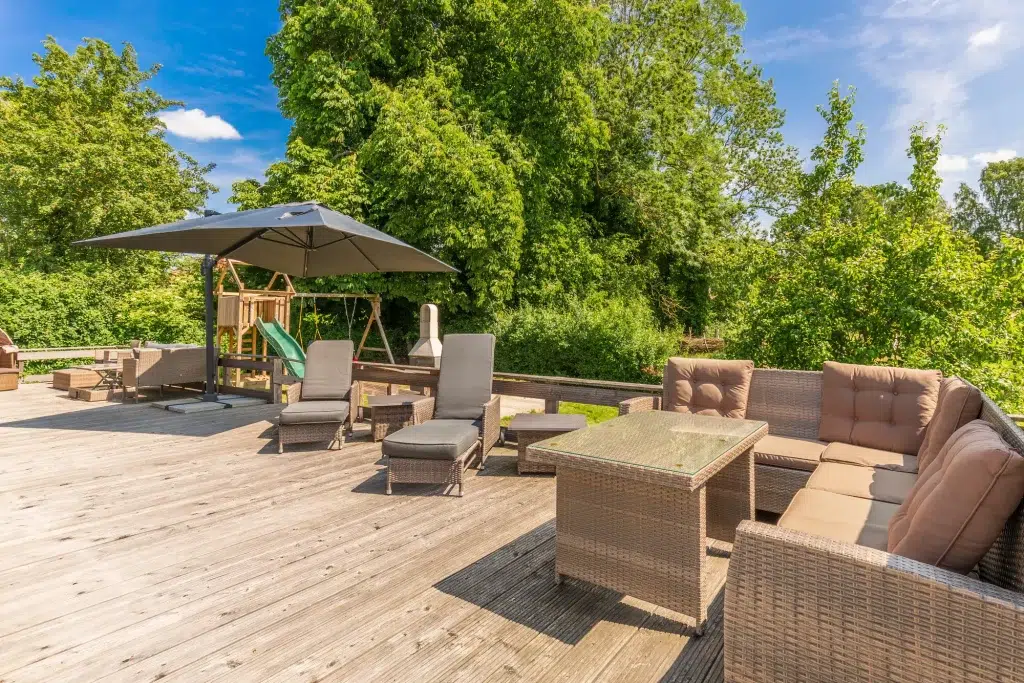 Ferienhaus Saphir Damshagen – Außenbereich, Holzterrasse mit Liegen und Sitzmöglichkeiten und Spielecke